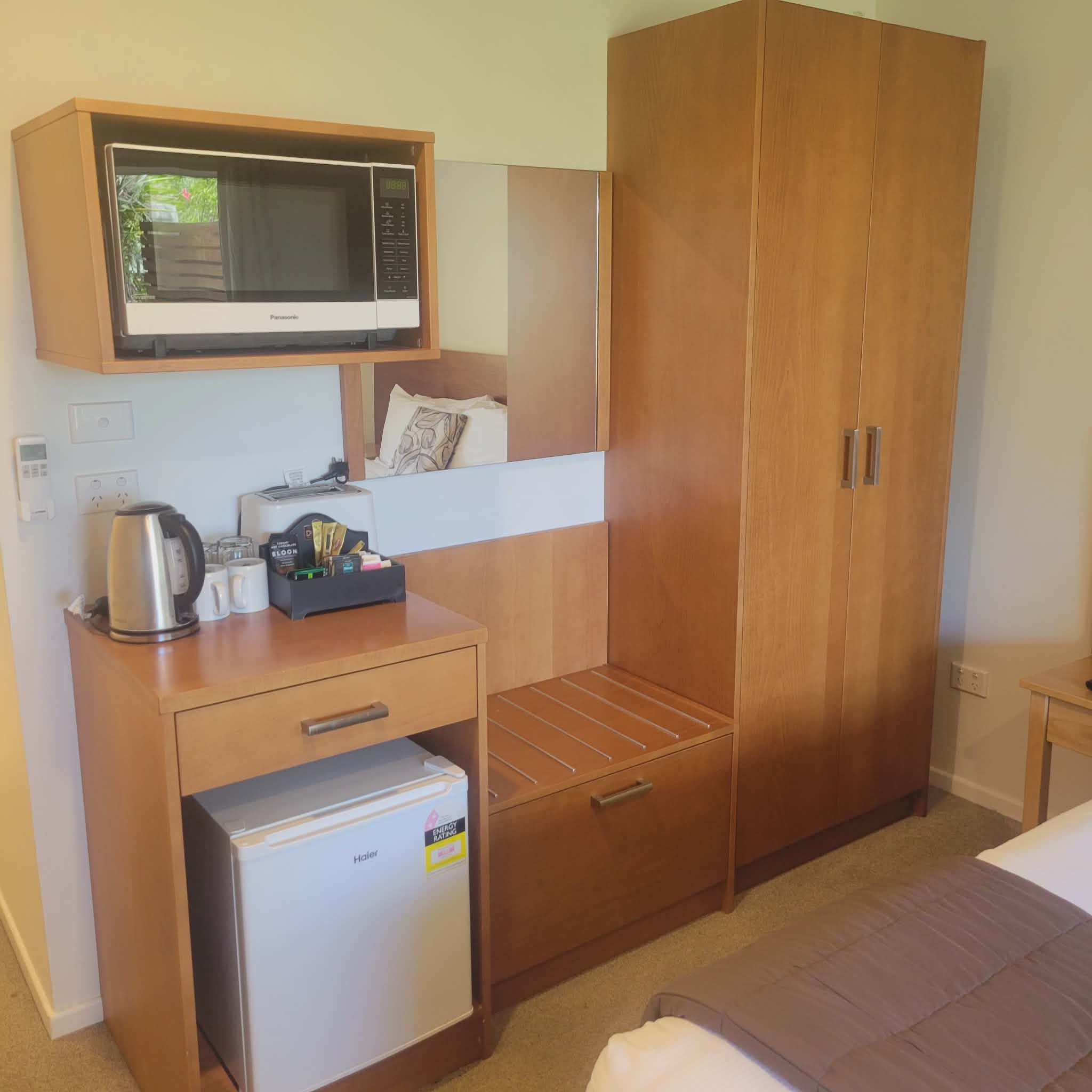 Taipa Beach Resort room amenities including microwave, minibar fridge, tea and coffee station, and wardrobe.