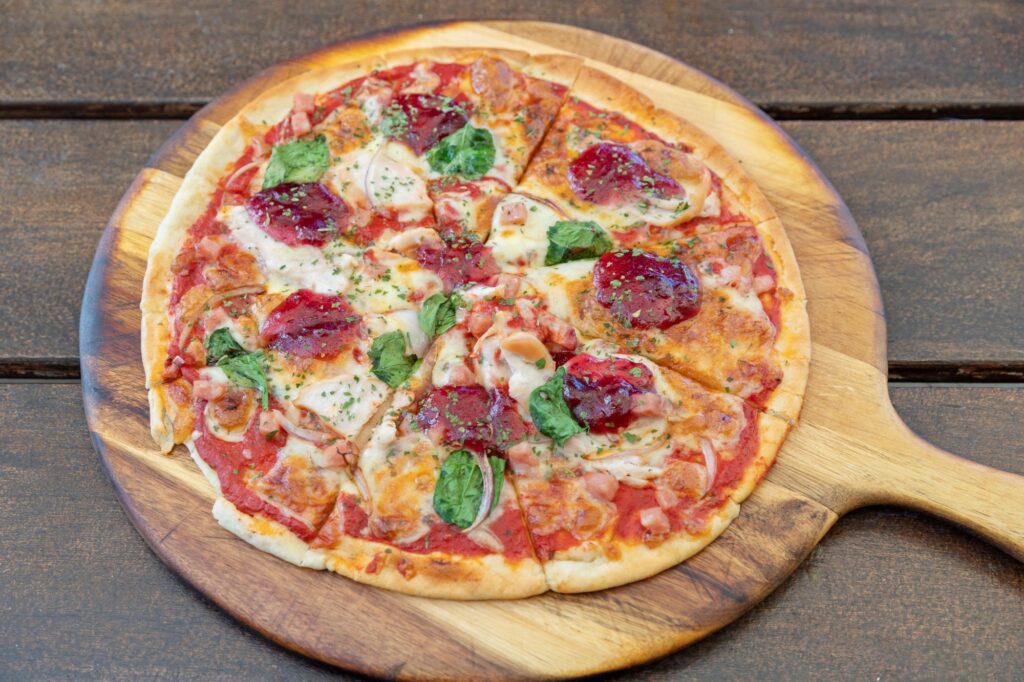 Stone-baked pepperoni pizza with mozzarella, fresh basil and tomato sauce served at Taipa Beach Resort Restaurant in Doubtless Bay, Northland.